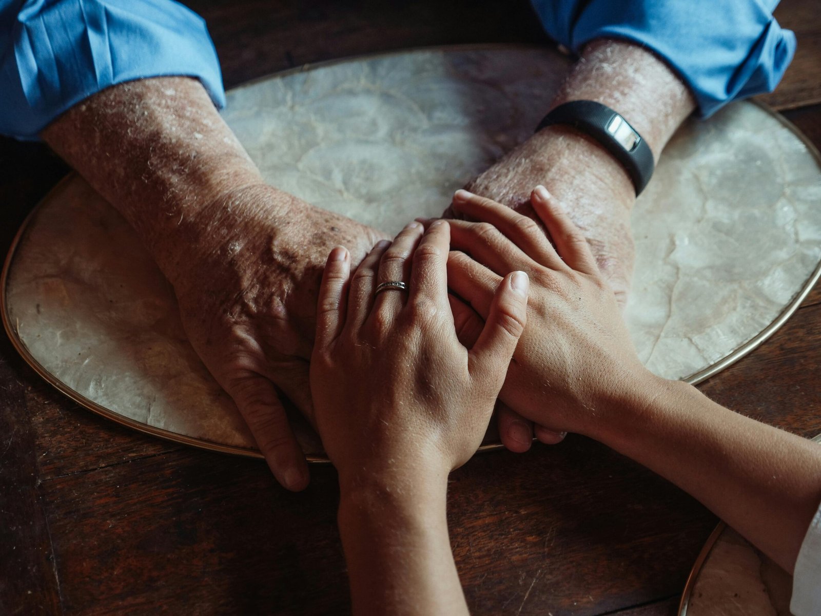 Close-up of elderly and young hands joined, symbolizing compassion and support.